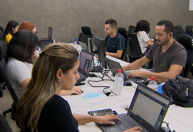 Pessoas trabalham com computador.